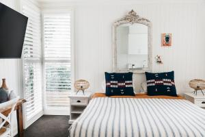 吉朗Anchor Geelong的卧室配有一张壁挂镜子的床