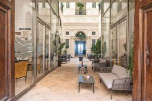 特拉帕尼Central Gallery Rooms- Palazzo D'Ali' Staiti XIX的大堂设有玻璃墙、沙发和桌子。
