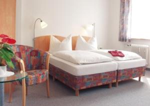 菲林根-施文宁根Hotel Bären的一间卧室配有一张床、一张沙发和一张桌子