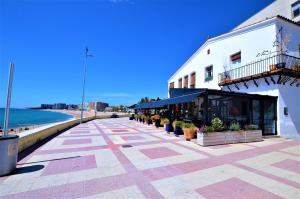 布拉内斯LUXURY HOUSE 8 PERSONS FRONT THE BEACH BLANES COSTA BRAVA的海滩旁的一座建筑旁的一条人行道