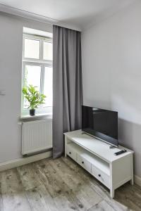 霍茹夫Niebieski Apartament DE LUX dla 4 osób Chorzów Katowice的一间客厅,客厅内配有白色梳妆台上的电视