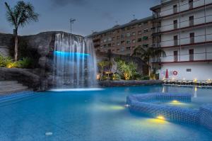 马尔格莱特德玛帕皮酒店的一座大楼前带瀑布的游泳池