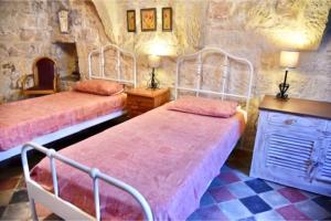 休吉让Ta'Martin Farmhouse Xewkija Gozo的石头客房设有一间带两张床的卧室