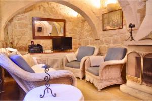 休吉让Ta'Martin Farmhouse Xewkija Gozo的客厅配有藤椅和壁炉