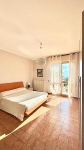 蒙蒂尼奥索Beatrice Apartment Crocello的一间卧室设有一张大床和一个大窗户