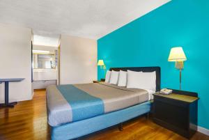 布拉格堡布拉格堡第6汽车旅馆的一张大床,位于一个蓝色的墙壁内
