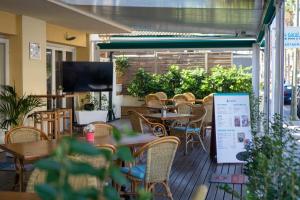 帕尔马海滩Coral beach house & food的一个带桌椅的餐厅庭院和一台平面电视