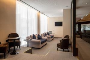 格拉纳达格拉纳达中心酒店的客厅配有沙发、椅子和电视