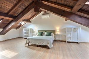 帕维亚卡西内托公寓式酒店的一间带一张床的卧室,位于带木制天花板的房间内