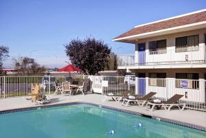 特劳特代尔东波特兰6汽车旅馆 - 特劳特代尔的酒店前方的游泳池设有椅子和庭院