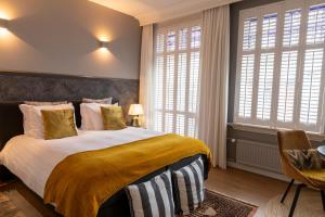 马斯特里赫特Guesthouse Thoez的一间卧室设有一张大床和两个窗户。