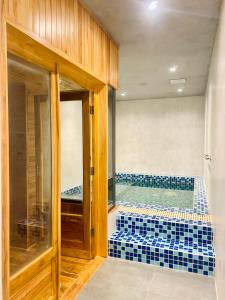 广义NEWCC HOTEL AND SERVICED APARTMENT的浴室铺有蓝色瓷砖,