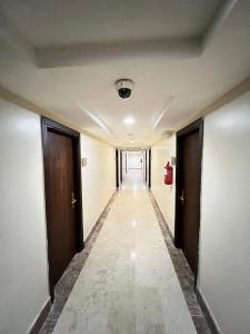 麦加Al Tayseer Towers Tuwa Hotel فندق ابراج التيسير طوى的走廊设有两扇门,走廊设有长长的走廊