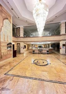 麦加Al Tayseer Towers Tuwa Hotel فندق ابراج التيسير طوى的一个带吊灯的大型大堂和一间大房间