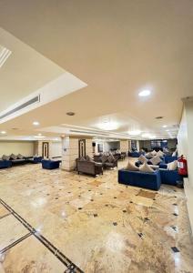 麦加Al Tayseer Towers Tuwa Hotel فندق ابراج التيسير طوى的一间大房间,位于一座建筑中,配有沙发和椅子