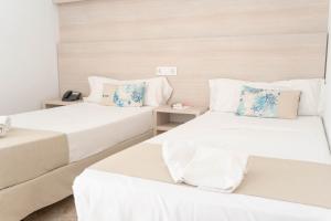 帕尔马海滩Coral beach house & food的配有白色和蓝色枕头的客房内的两张床