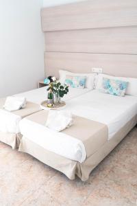 帕尔马海滩Coral beach house & food的两张带白色床单和鲜花托盘的床