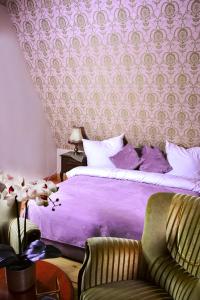 ZachełmieRezydencja Lawendowe Wzgórze的一间卧室配有一张紫色的床和一把椅子