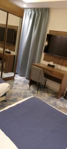 艾卜哈فندق ايديا的客厅配有电视和带电脑的书桌