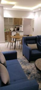 艾卜哈فندق ايديا的客厅配有2张蓝色的沙发和1张桌子
