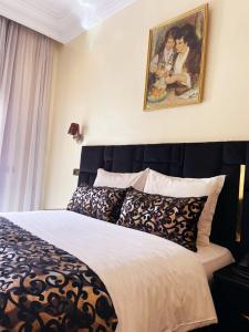 卡萨布兰卡阿斯托利亚酒店的卧室配有一张床,墙上挂有绘画作品
