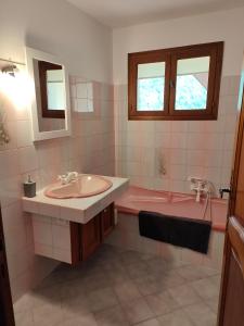 BoutxCHALET BOUTX 6 PERSONNES的一间带粉色浴缸和水槽的浴室