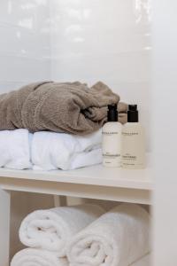 洛坎杰B&B Buytenlust的一个带毛巾和两瓶洗发水的架子