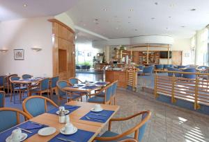 菲尔德施塔特Hotel Schwanen Stuttgart Airport/Messe的餐厅设有木桌和蓝色椅子