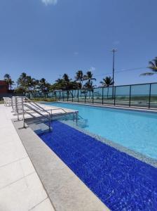 累西腓Rio Park Avenue Number 2 - By TRH Invest的一座拥有蓝色海水和棕榈树的游泳池