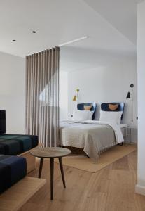 哥本哈根Apartments by Brøchner Hotels的一间卧室配有一张床、一张沙发和一张桌子