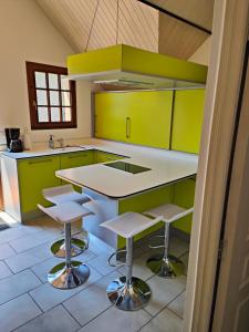 BoutxAppartement Boutx的厨房配有绿色橱柜和带凳子的台面