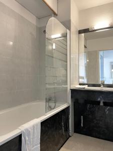 阿卡雄Appart'hôtel Le Trianon的带淋浴、浴缸和盥洗盆的浴室