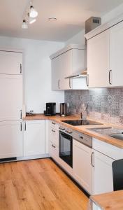 WincheringenWine & Hike的白色的厨房配有白色的橱柜和木地板。