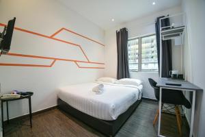 吉隆坡Meta Hotel的一间卧室配有一张床、一张书桌和一个窗户。