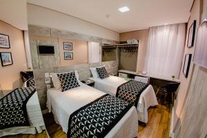 维索萨Bristol Viçosa Hotel的酒店客房设有两张床和电视。