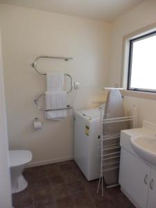 皇后镇瓦卡蒂普湖景公寓的一间带水槽和白色冰箱的浴室
