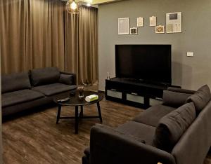 Ţāb Kirā‘Elite Corner Apartment的客厅配有2张沙发和1台平面电视