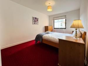 格拉斯哥Anniesland Glasgow 1bd Flat - Free Parking的一间卧室配有一张床,铺有红色地毯