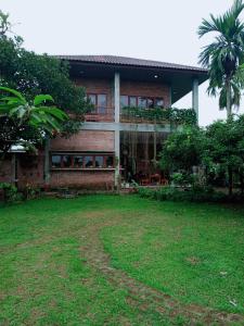 棉兰Bua Guest House的前面有一座绿色庭院的房子