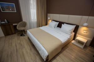 第比利斯History Hotel Tbilisi的一间卧室配有一张大床和一把椅子