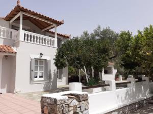 帕诺尔莫斯斯科派洛斯Villa Tillia的白色的房子,有白色的栅栏和树木
