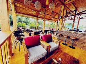 拜县Supermoon Cozy Hostel的餐厅设有酒吧,配有长凳和桌子