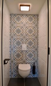佐特兰德Luxe vakantievilla Zoutelande的一间带卫生间和瓷砖墙的浴室