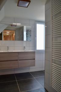 佐特兰德Luxe vakantievilla Zoutelande的一间带两个盥洗盆和大镜子的浴室