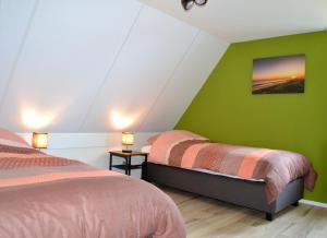佐特兰德Luxe vakantievilla Zoutelande的一间卧室设有两张床和绿色的墙壁