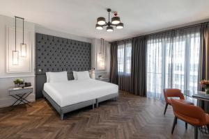 伊斯坦布尔Wish More Hotel Şişli的卧室配有白色的床和桌椅