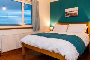Atlantic views at Arnisdale House的一间卧室设有一张带绿色墙壁和窗户的床。