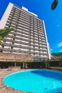 瓜鲁雅Ferraretto Guarujá Hotel & Spa的一座大型建筑,前面设有一个大型游泳池