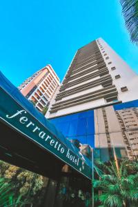 瓜鲁雅Ferraretto Guarujá Hotel & Spa的一座高楼前的酒店标志