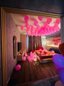 芹苴MIS HOSTEL Cần Thơ的天花板上悬挂着粉红色气球的房间